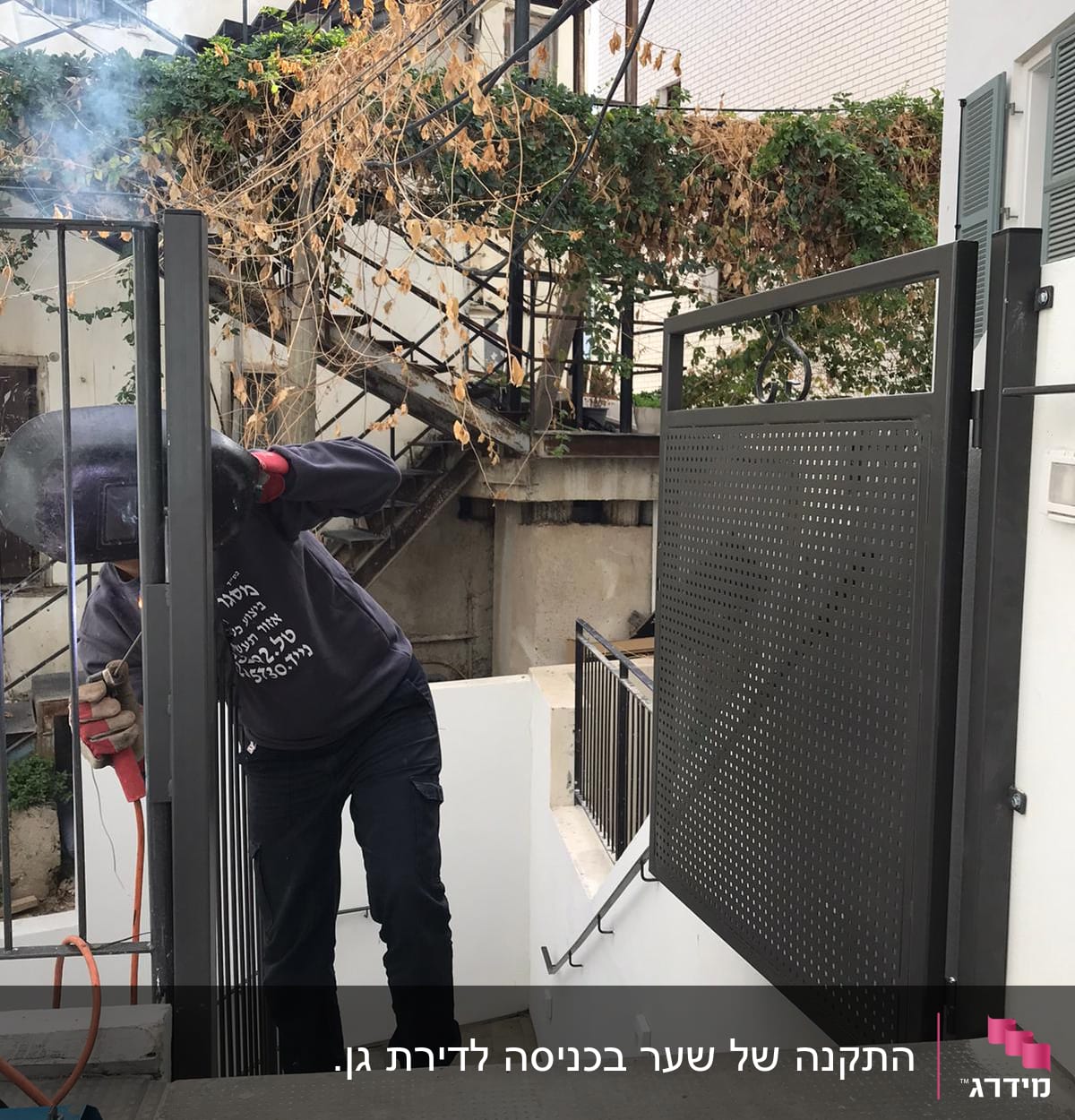 אדם מרתך מסגרת מתכת בשער חיצוני